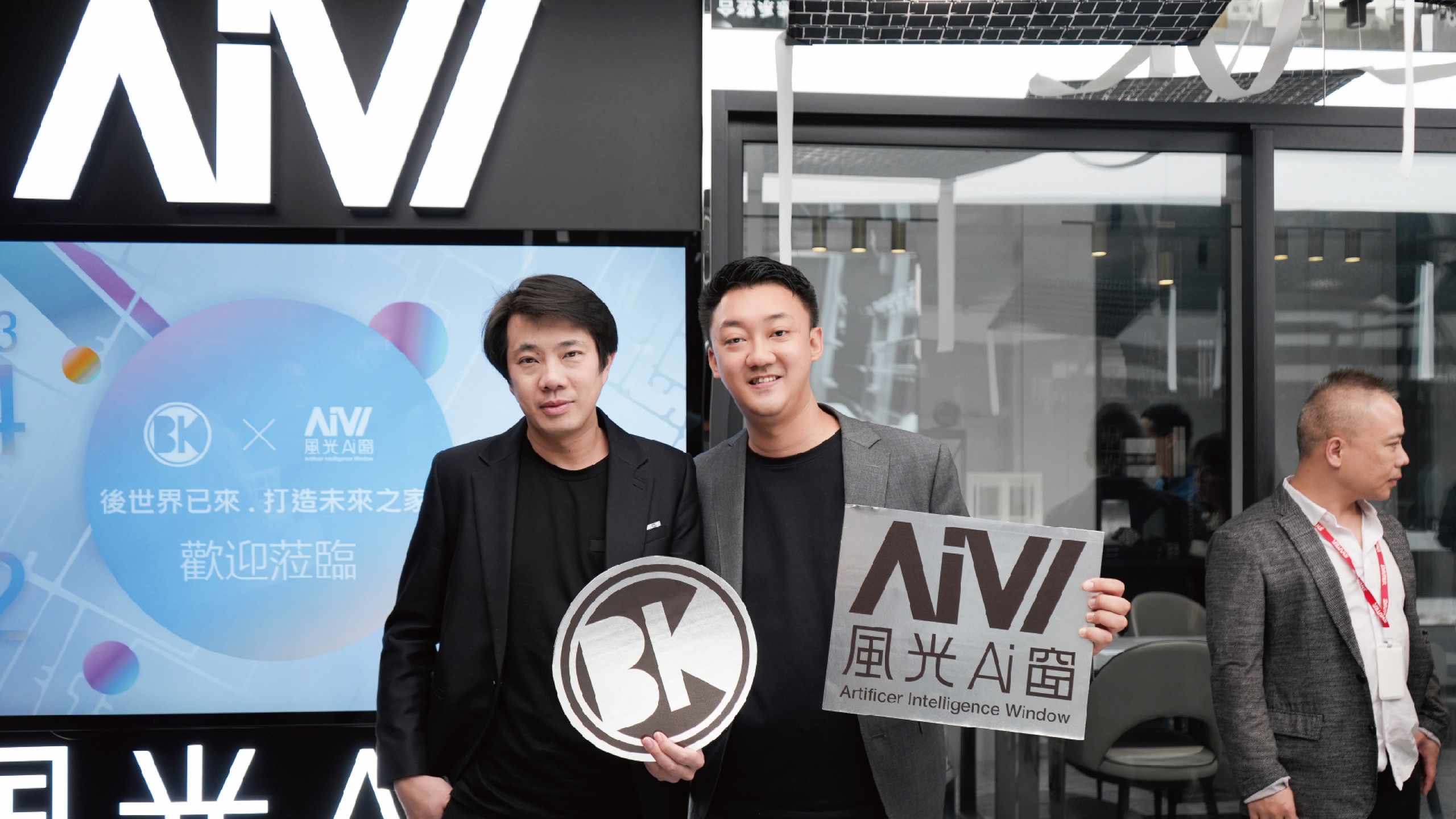 BKA 後次元潮流與風光Ai窗雙方代表於「後世界已來．打造未來之家」歡迎背板前合影，各持品牌手牌